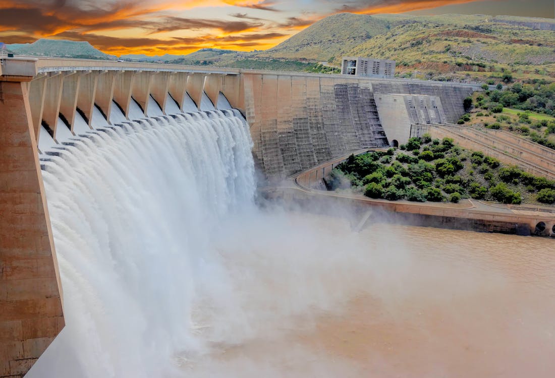 Large dam with water flowing from its gates, indicating a good use case of InSAR monitoring for the water sector